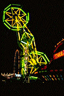 of one of thrilling double Ferris wheels, outlined by yellow and green neon lights against the night air.